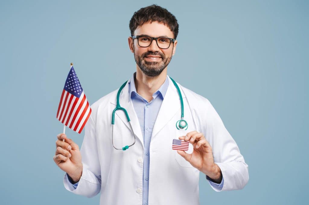 Healthcare professional standing ,holding a flag of the USA, symbolizing resilience during The Great Resignation.