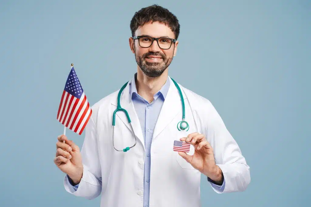 Healthcare professional standing ,holding a flag of the USA, symbolizing resilience during The Great Resignation.