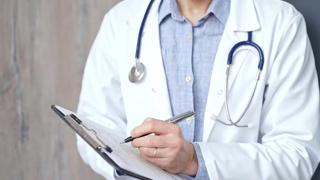 A professional doctor updates medical charts, which is what a virtual medical scribe do