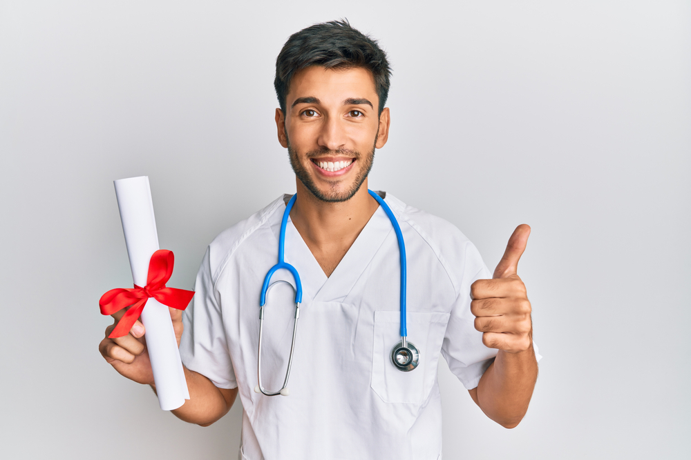 A virtual medical scribe in scrubs, smiling while holding a certificate.