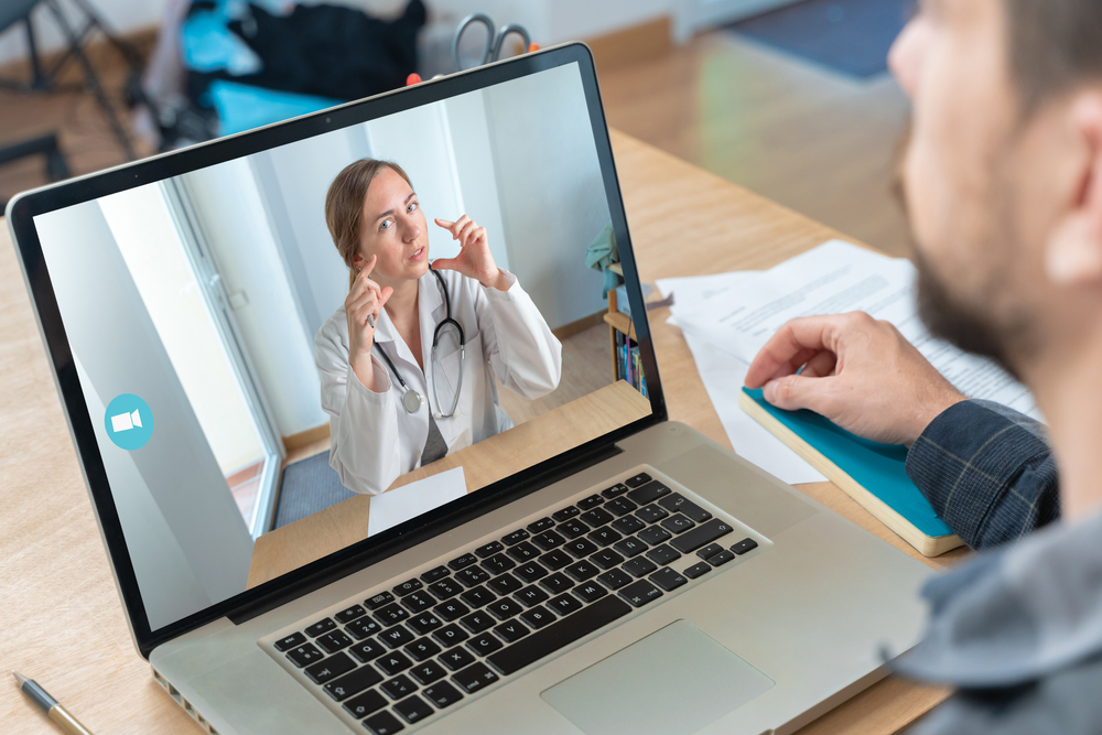Patient making a video call through his laptop to a VMeDx virtual medical receptionist.