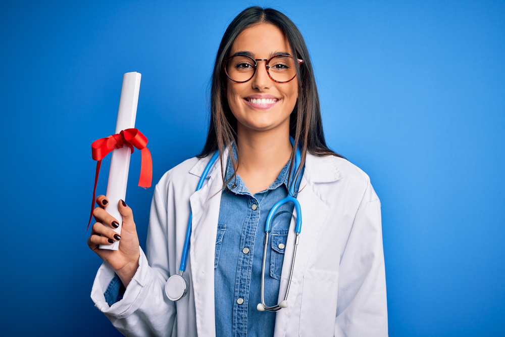 female medical graduate holding her certificate.