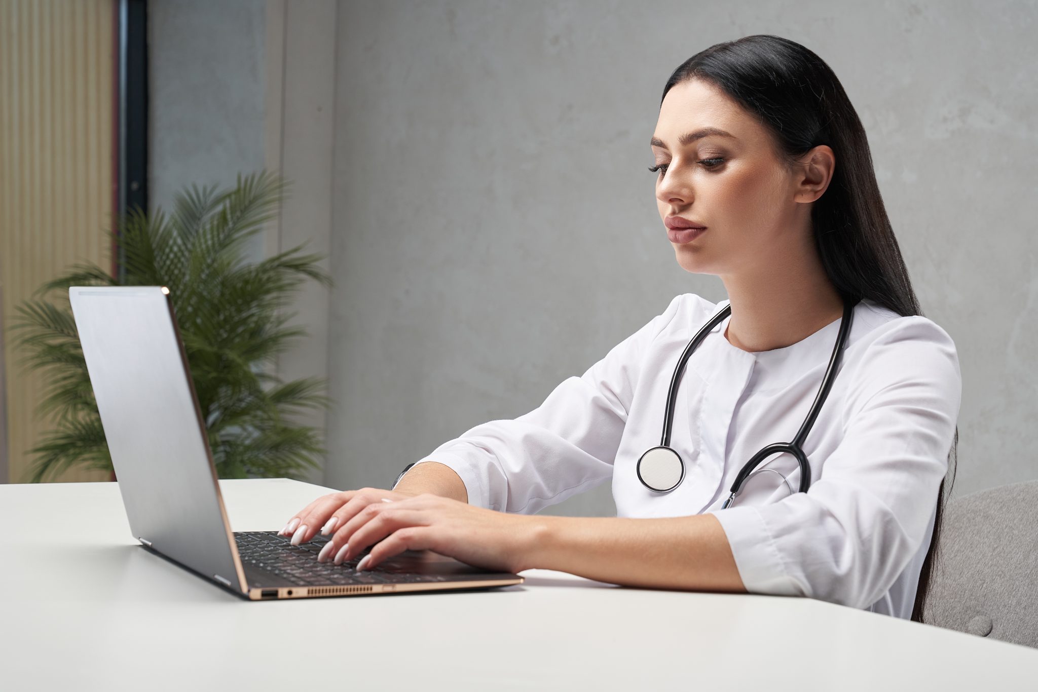 fmale doctor using a laptop, what does a virtual medical scribe do