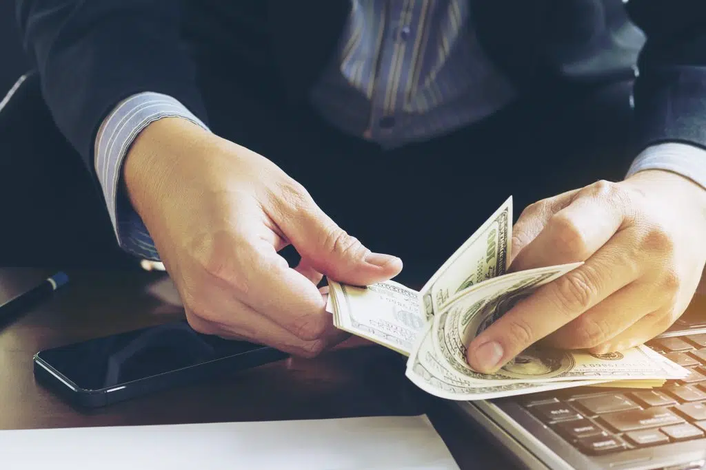 remote-medical-scribe-salary-business-man-counting-dollar