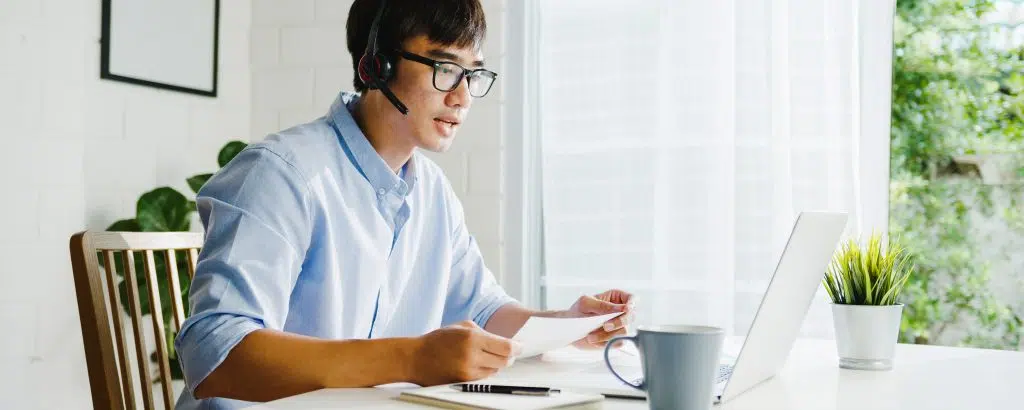 businessman using a laptop on a video call while working from home, showcasing medical scribe virtual jobs in a remote work setting
