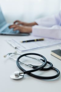 an image of psychiatrist medical virtual scribe typing on his laptop