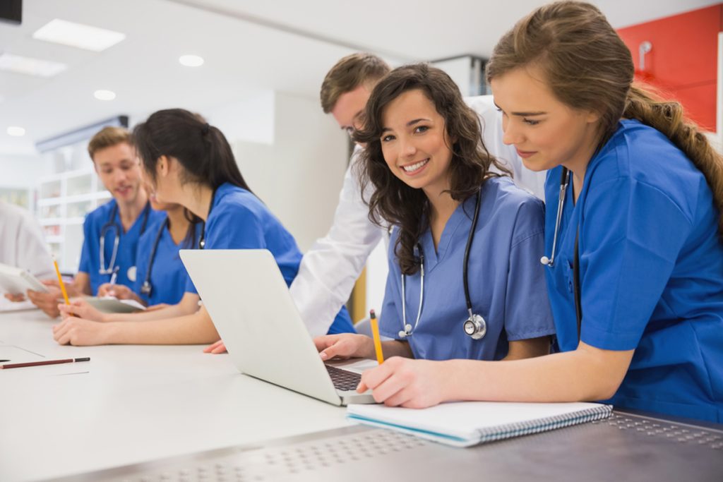 A group of medical virtual assistants in training, smiling at the camera.