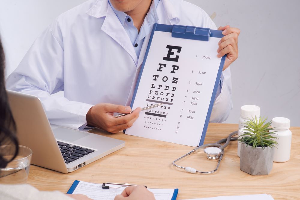 Medical opthalmologist scribe pointing at the letters on the eye chart.