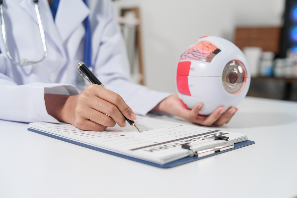 Virtual medical scribe of ophthalmologist holding an eye model ,documenting on his clipboard.