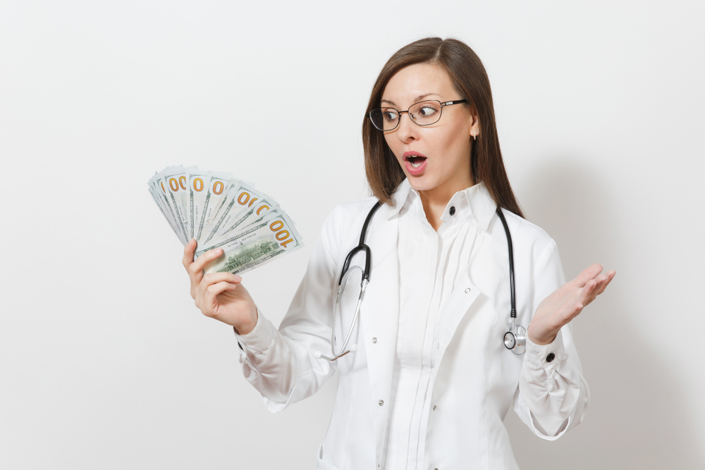 A female holding a cash representing "how much do virtual medical scribe make