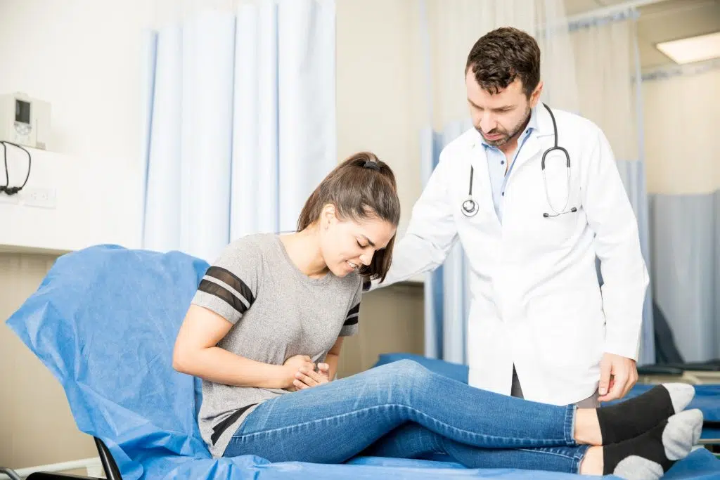 a woman having a stomach ache visting the doctor for treatment, gastroenterologist medical virtual scribe