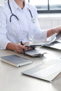 a female doctor holding a pen and a tablet at her hand