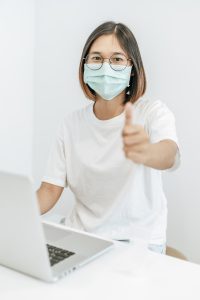 woman wearing mask showing thumbs up, best virtual medical scribes