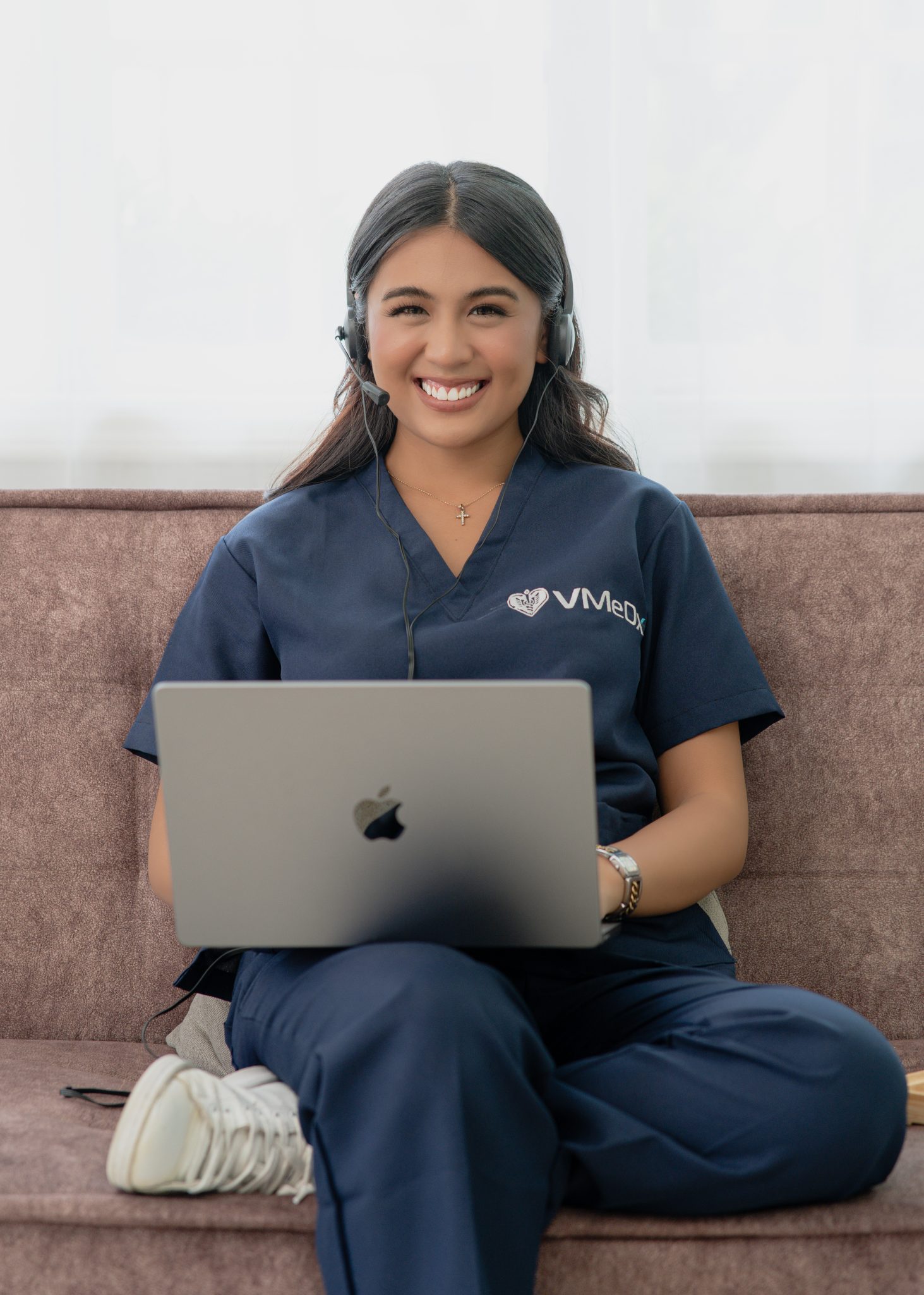 Female medical seo specialist, sitting at a couch working o her laptop.