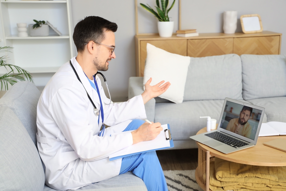 Remote health monitoring talking to his patient through video call while at home.