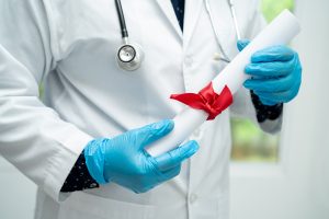 doctor holding diploma, diploma, graduation hat, and stethoscope, certified medical scribe 