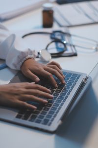 a hands of a doctor on laptop, medical administrative assistant 