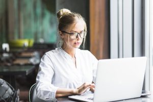 transformative virtual receptionist looking and typing on a laptop