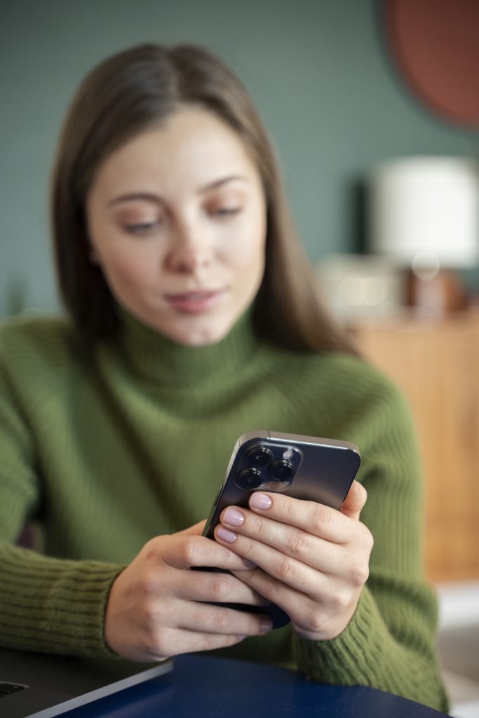 woman looking her smartphone while at home