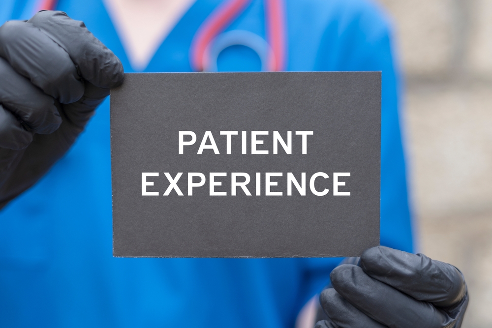 Doctor holding black card with inscription Patient experience.