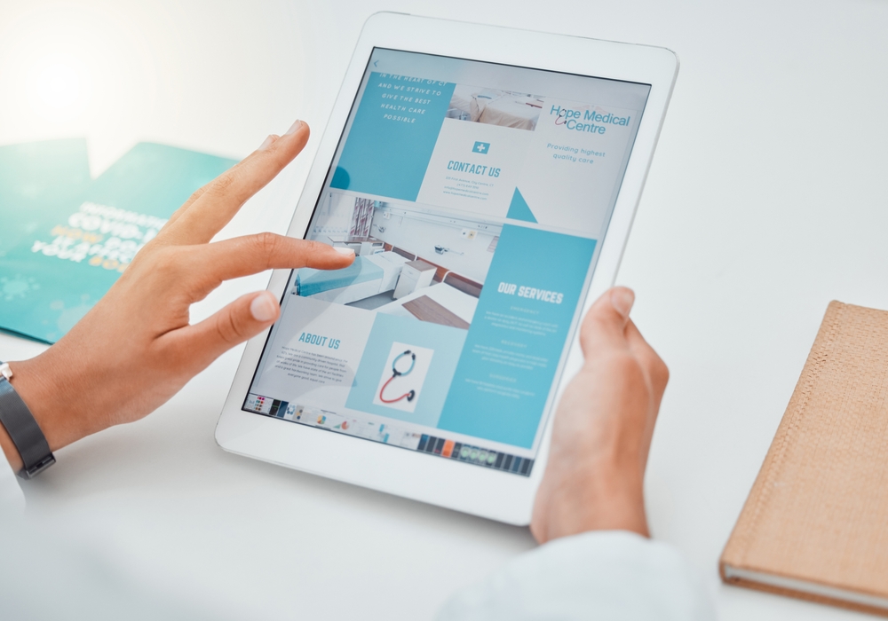 Hands holding a tablet displaying a 'Contact Us' section, featuring healthcare marketing and advertising on a medical industry website design,
