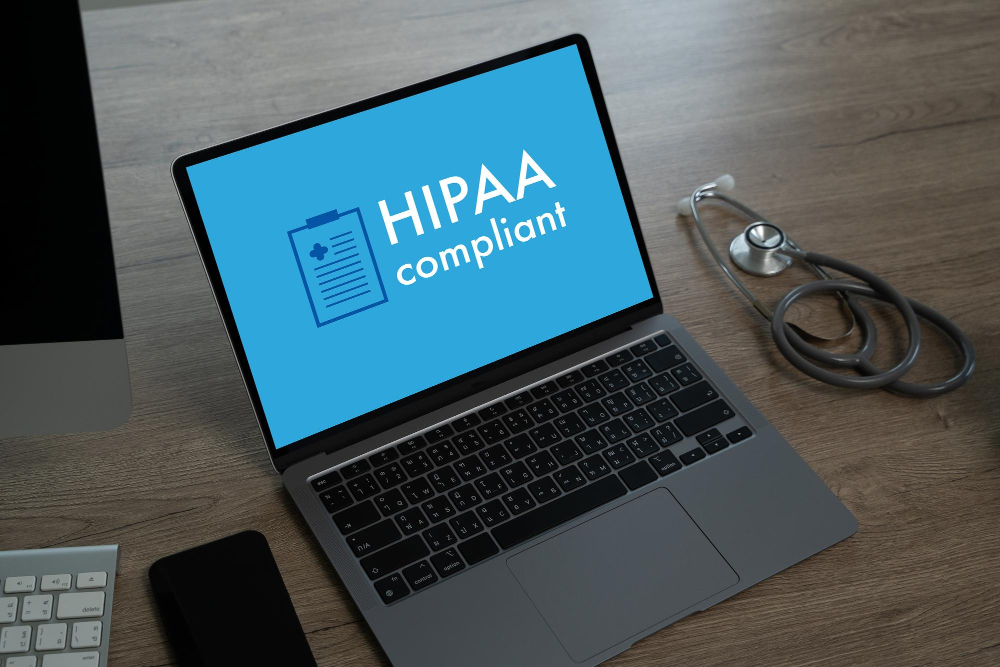 A laptop with the word HIPAA on it a table in hospital