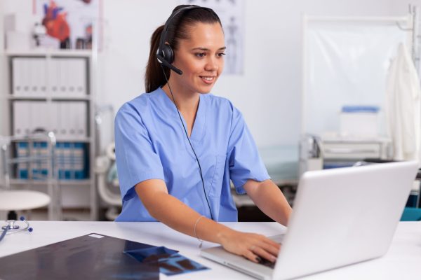 Female VA working on her laptop, exploring how to become a medical virtual assistant.