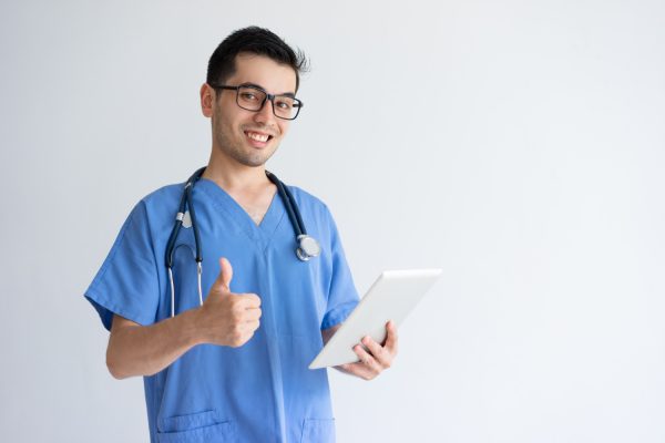Happy male virtual medical assistant holding a tablet showing thumbs up.