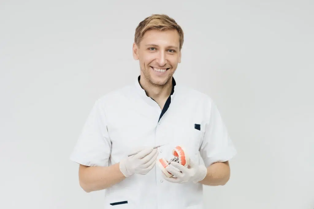 Male dentist holding a fake teeth in virtual assistant for dental professionals demo