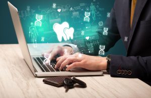 hand browsing on the internet for medical issues with dental icons coming out from the screen, dental practice management software