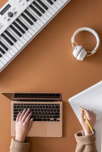 Musical background with musical keys, laptop and female hands, top view. academic transcription services for lecturers