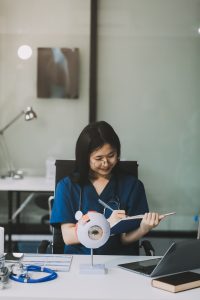 Ophthalmologist doctor in clinic, part of eye model on desk, oculus sample.