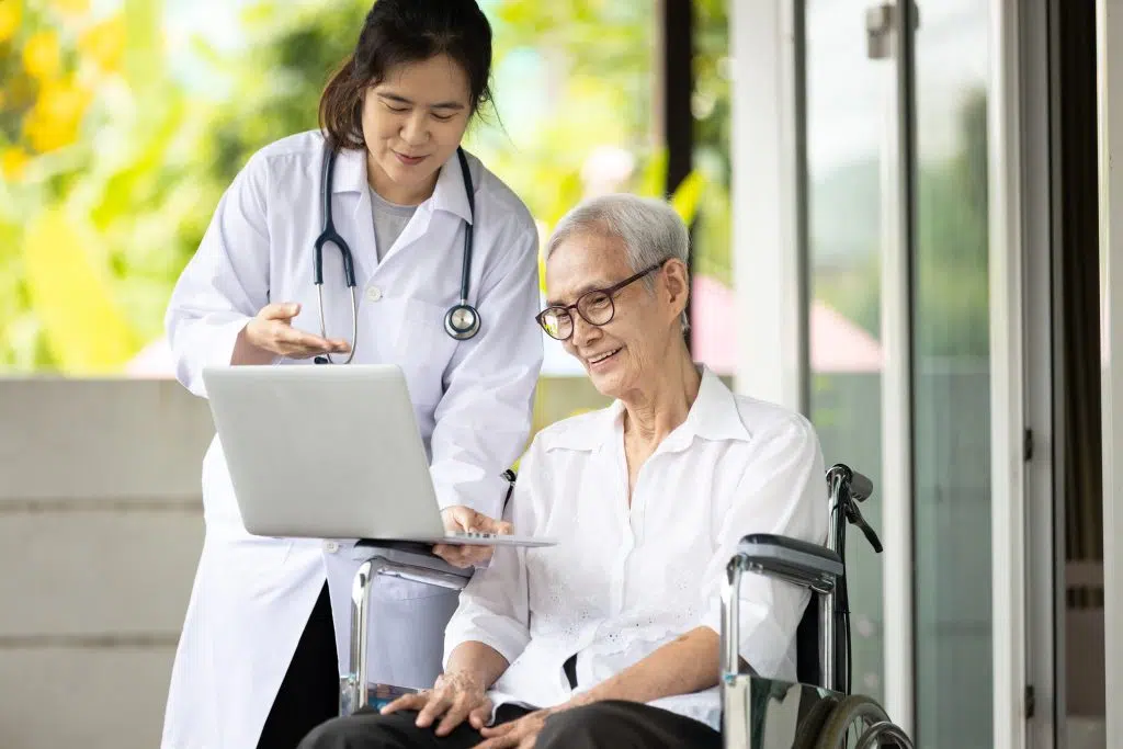 Global patient support services with patient looking at laptop.