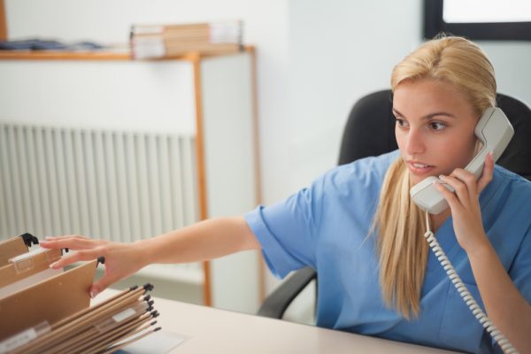 Nurse holding a phone while searching a folder