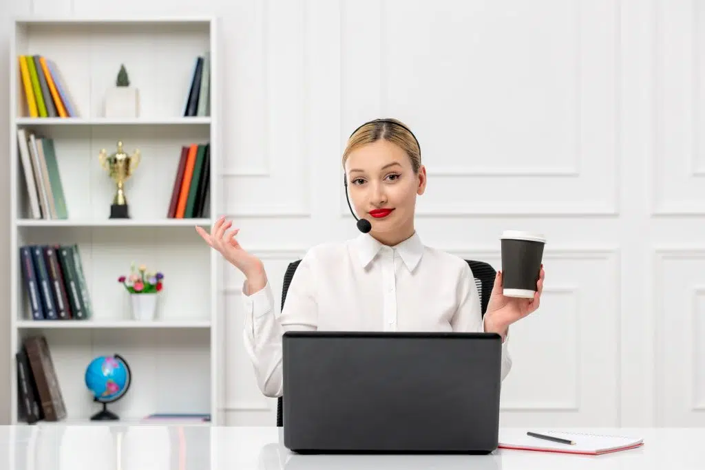 Customer service cute blonde girl office shirt with headset and computer holding a coffee cup, black friday efficiency receptionist