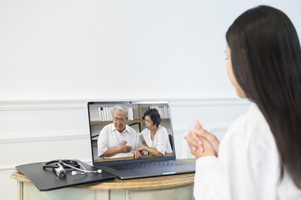 A female doctor making video call on social network with patient consulting about health problems, international patient scheduling services