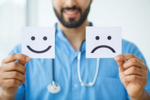 Health Care. Doctor Holding a Cards With Symbol Fun and Sad Smile, Medical Concept, healthcare challenges receptionist