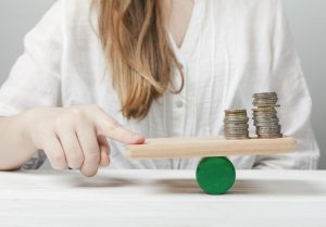 Woman holding her finger in balance with the coins, Woman holding her finger in balance with the coins