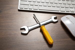 Wrench and screwdriver with a computer keyboard. IT Service. Support
