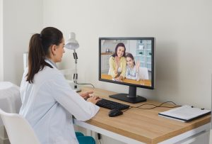 female doctor having a video call with a mother and a child.