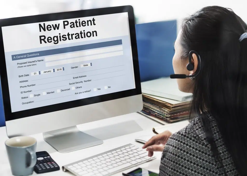 Patient access representative assisting with patient registration form