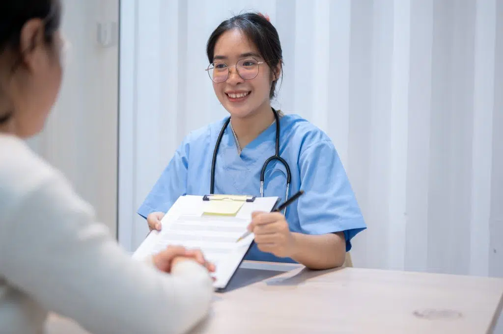 Patient coordinator explaining a medical document to a patient during an office meeting.