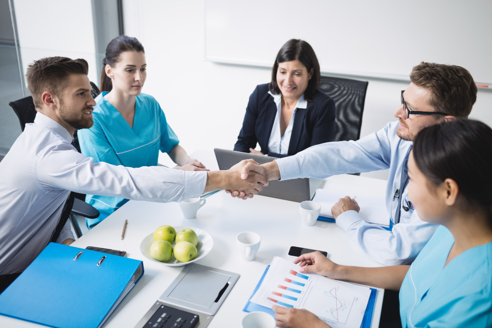 Doctors shaking hands in a hospital, supported by a virtual medical assistant.