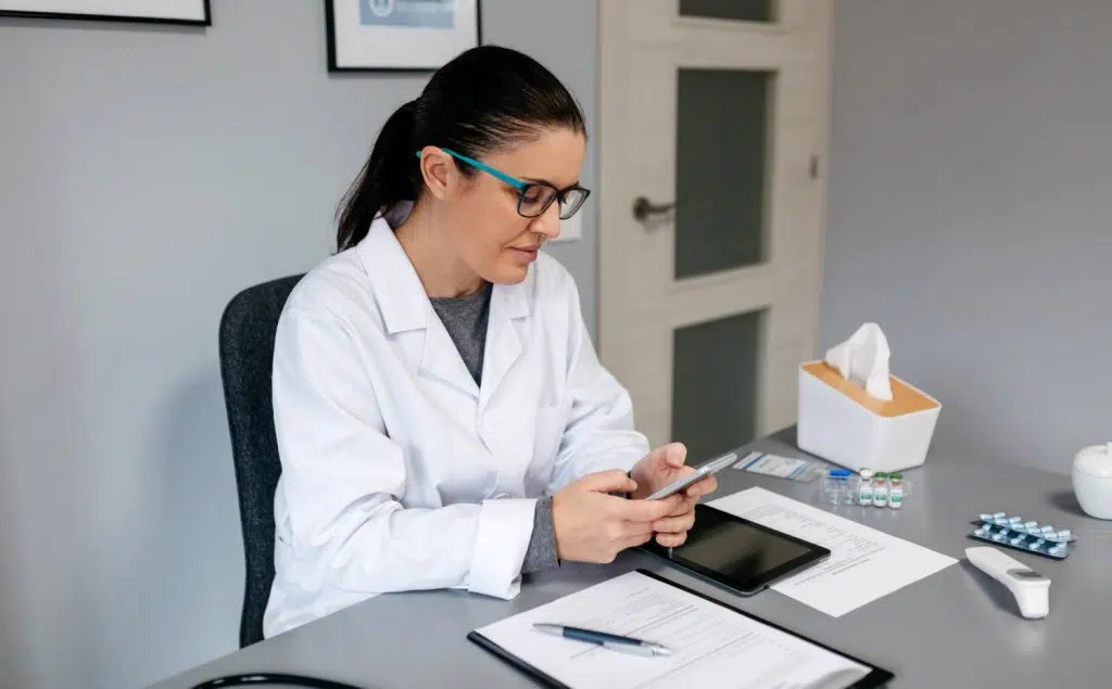 How to improve revenue cycle management, doctor using a digital tablet for calculations in a clinic office.