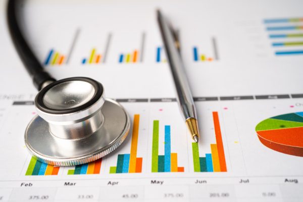How to improve revenue cycle management with a stethoscope and medical report on desk.