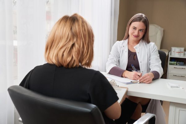 Medical receptionist writing down patient info