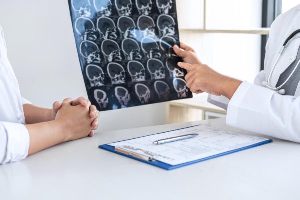 Neurologist assisting patient with registration and medical discussion.