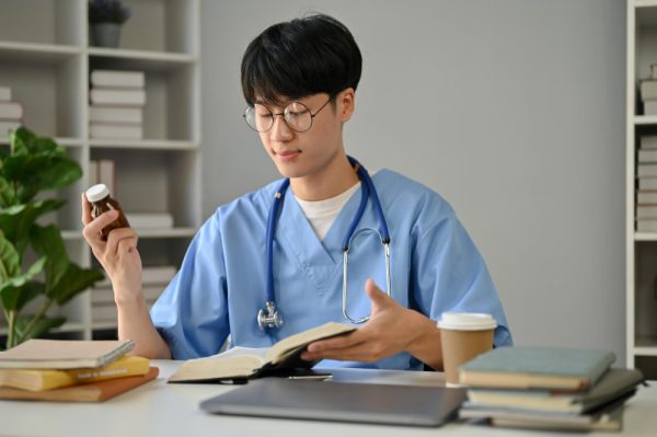 Virtual medical assistant, in blus scrubs holding a medicine.