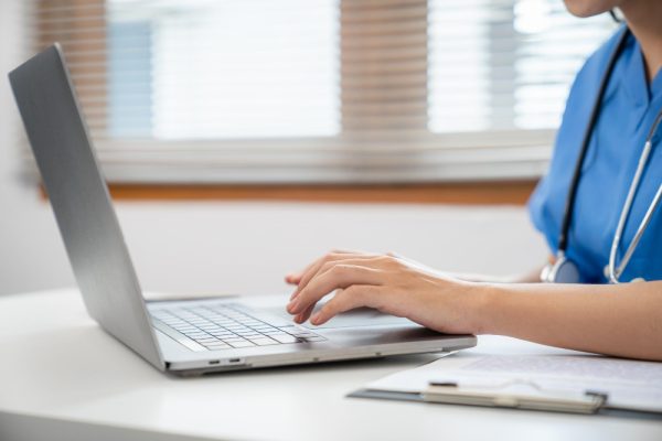Virtual medical scribe typing on a laptop keyboard.
