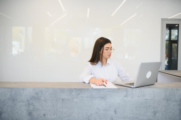 front desk receptionist using her laptop